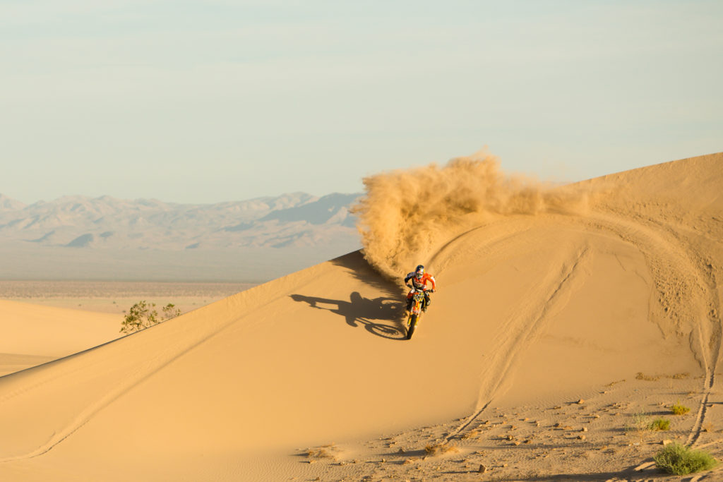 Ronnie Renner spraying sand in Dumont Dunes
